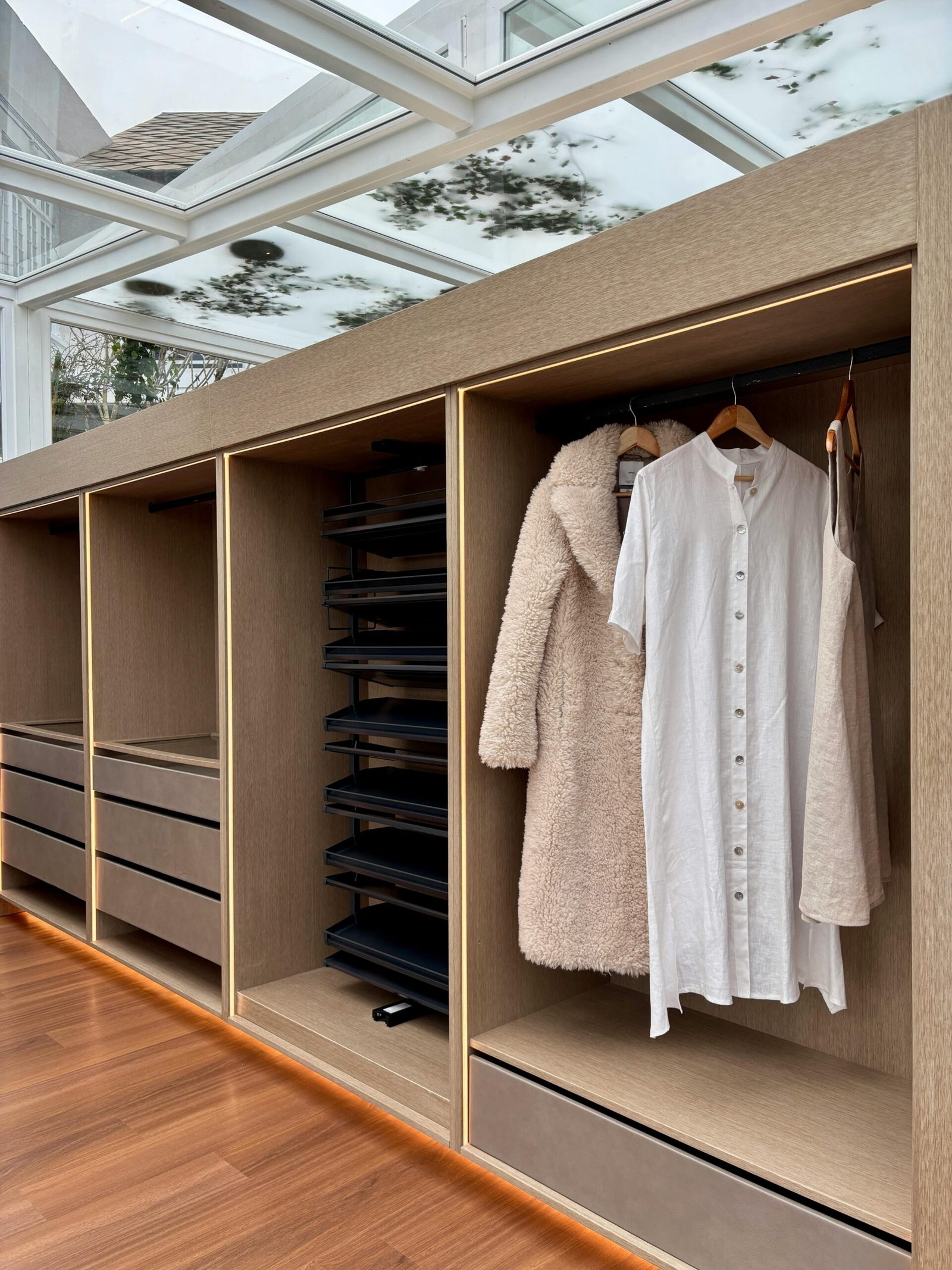 Contemporary wardrobe setting showcasing hanging garments including a coat and dress.