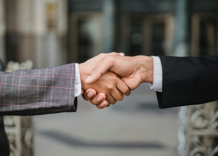 A close-up of two businesspeople shaking hands, symbolizing cooperation and partnership.